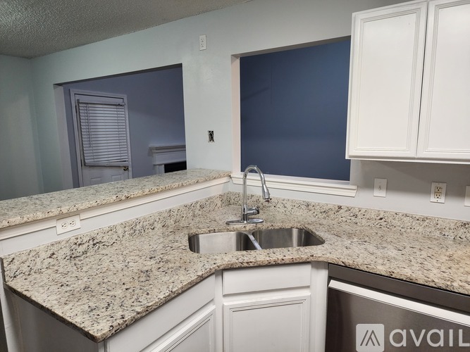 A kitchen with granite countertops and white cabinets.
