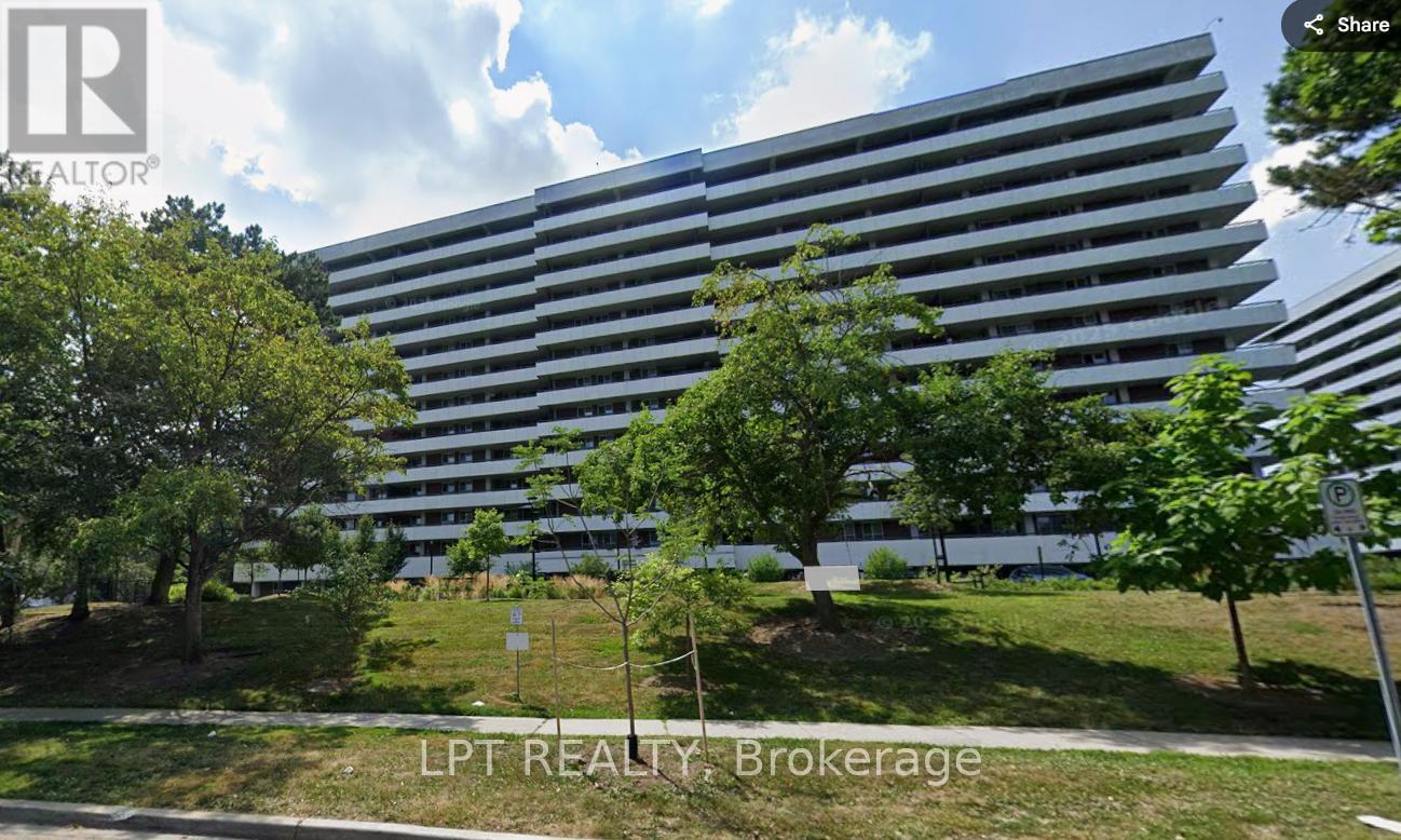 A large building with a lot of windows and trees in front.