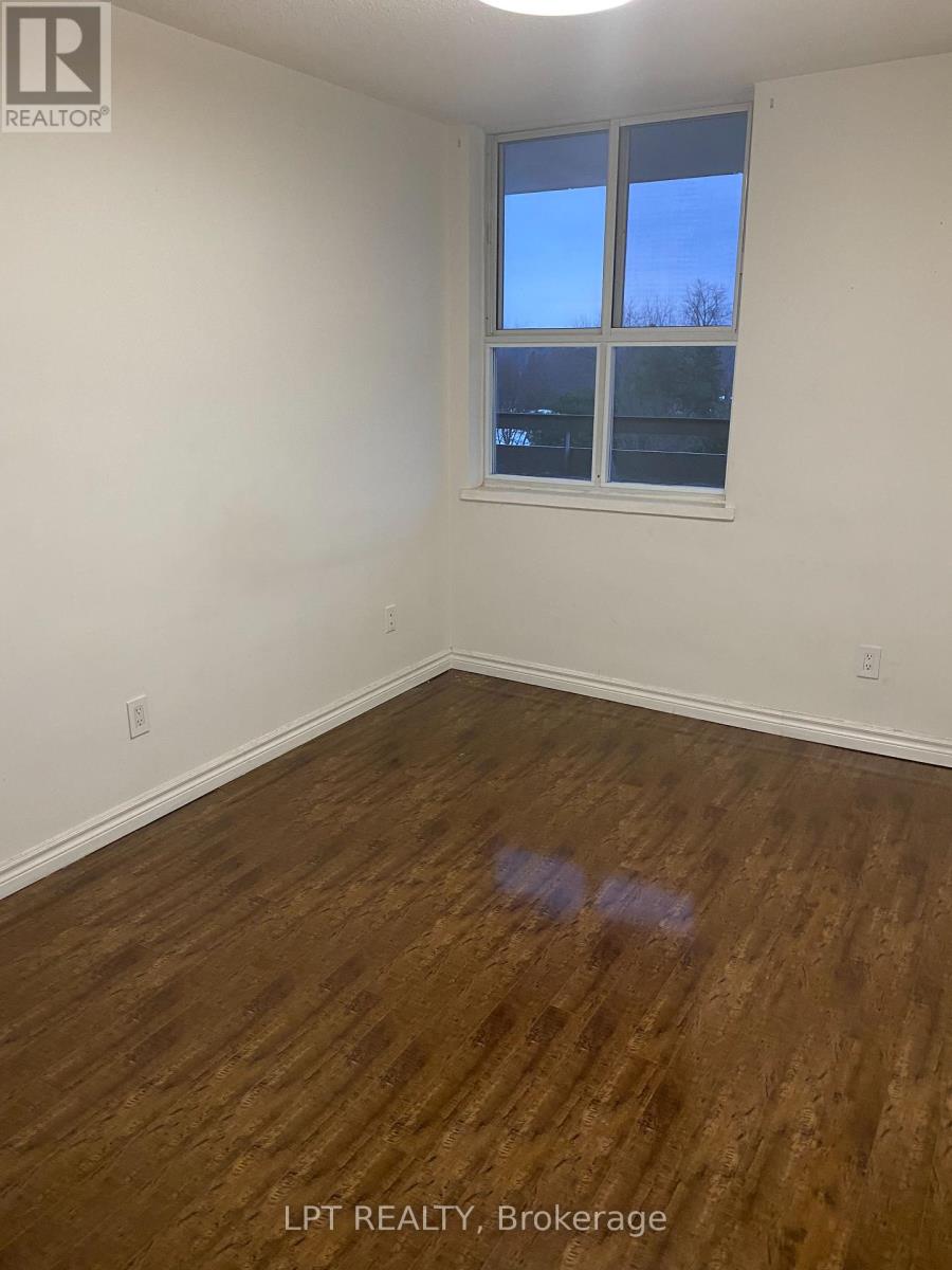 A room with wooden flooring and a window showing a blue sky.