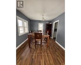A dining room with a wooden table and chairs.