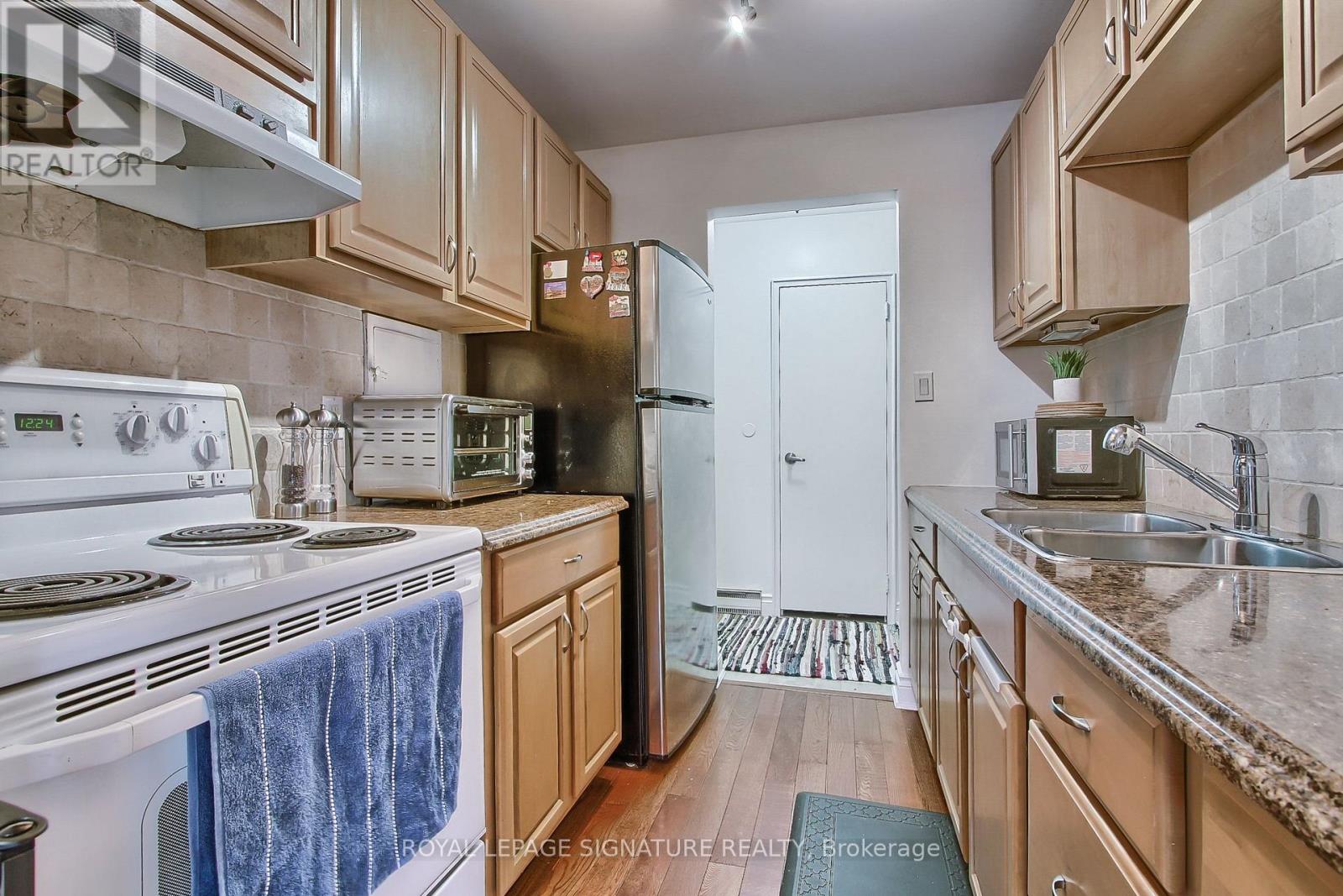 A kitchen with wooden cabinets and a white stove top oven.