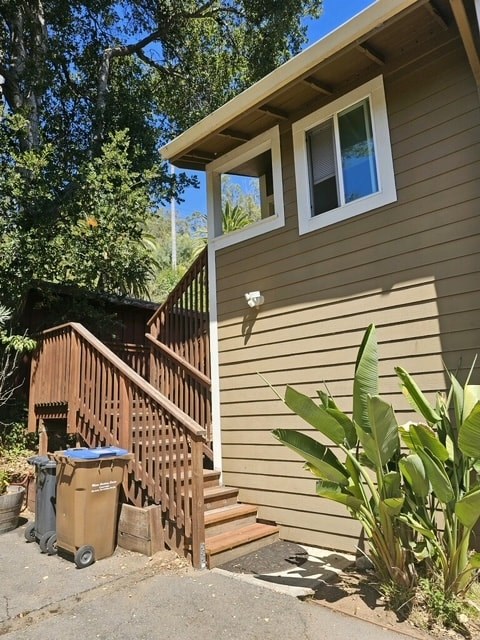 A house with a brown siding and a brown wooden staircase.