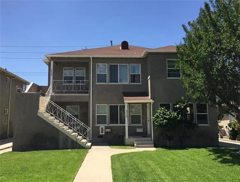 A grey house with a staircase leading to the second floor.