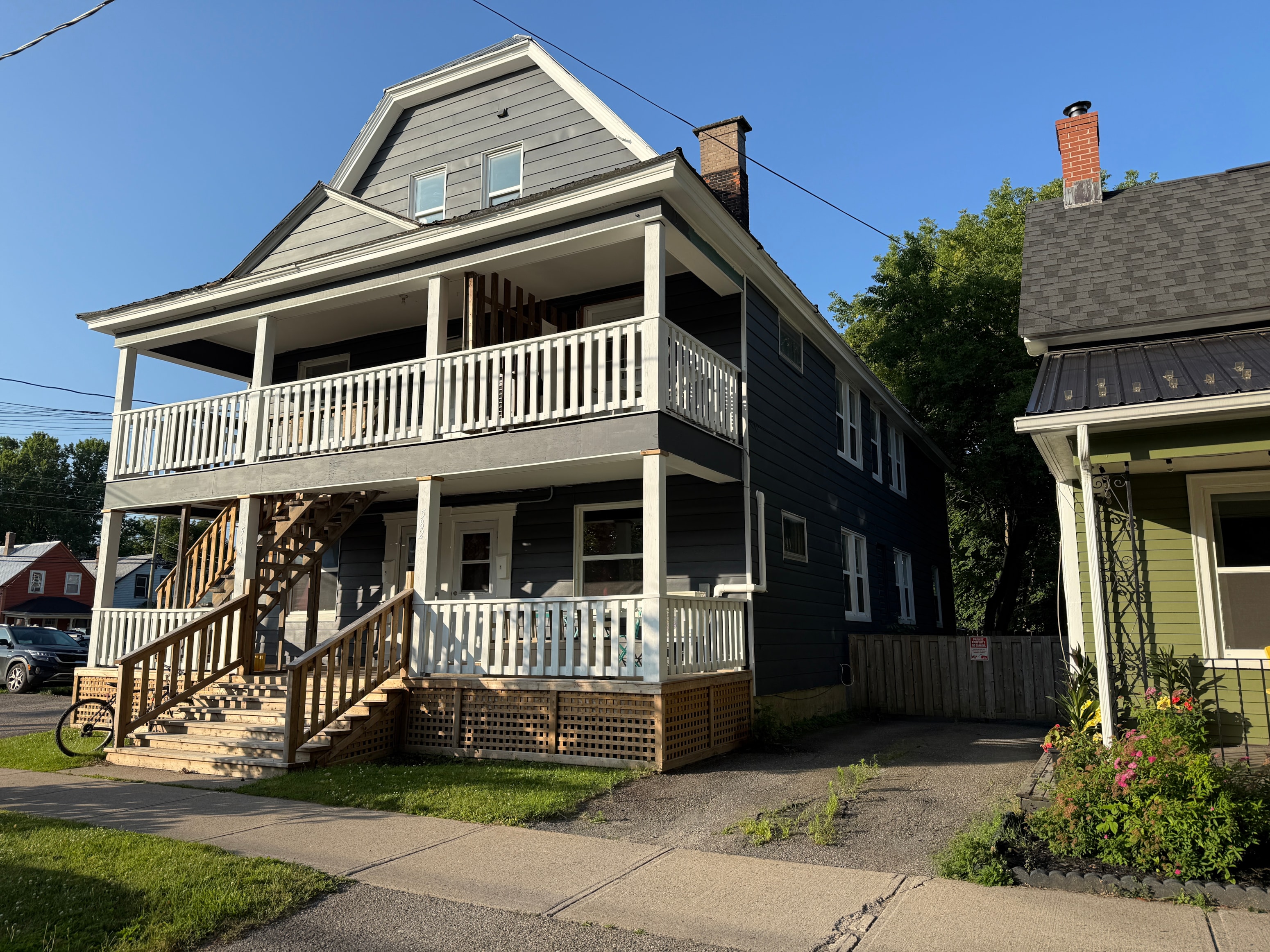 A two-story house with a porch and a staircase leading to the second floor.