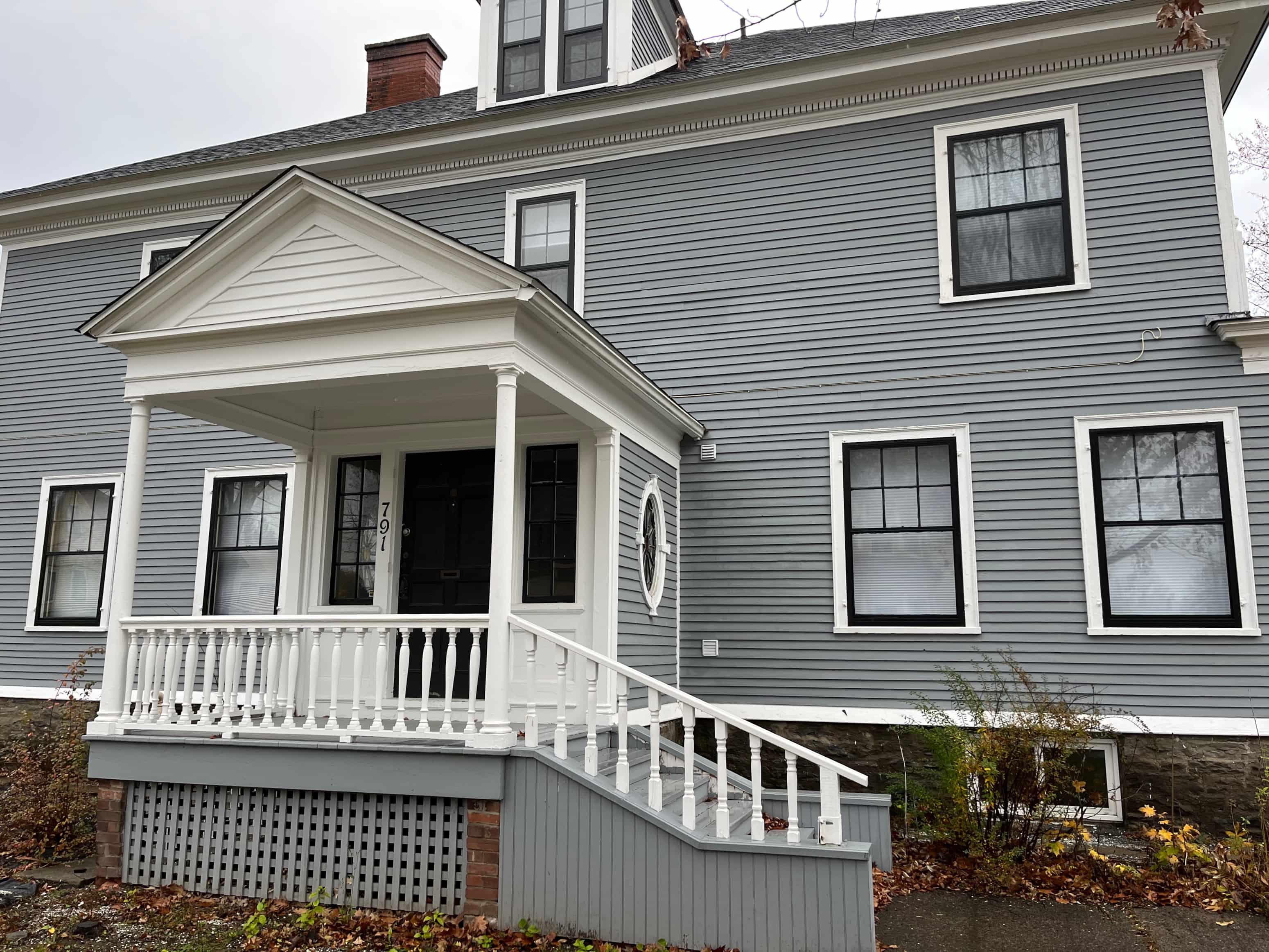 A house with a grey front and white porch.