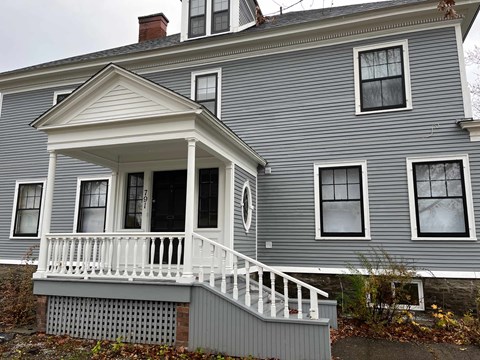 A house with a grey front and white porch.