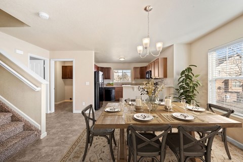 A dining room with a table set for four.