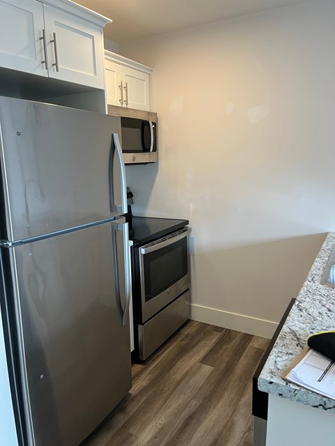 A kitchen with a stainless steel refrigerator and oven.