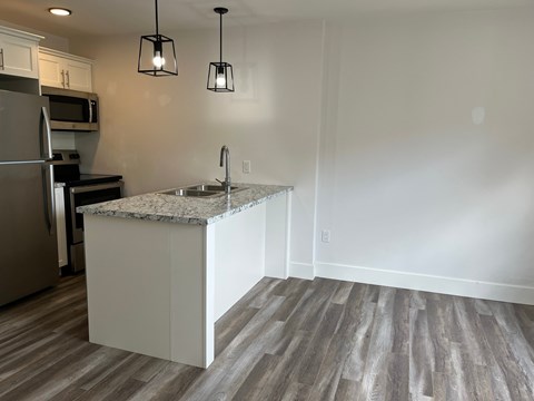 A kitchen with a marble countertop and a refrigerator.