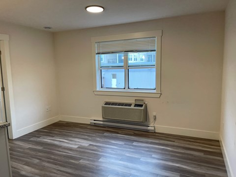 A room with a window and a wall-mounted air conditioner.