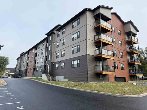 A large apartment building with a parking lot in front.