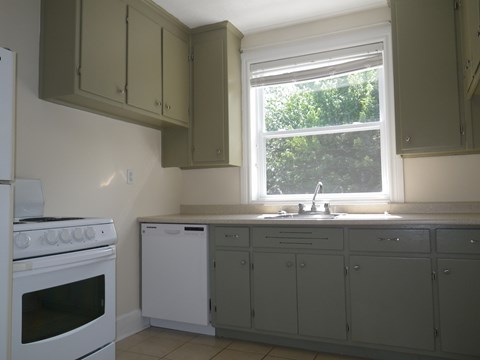 A kitchen with white appliances and grey cabinets.
