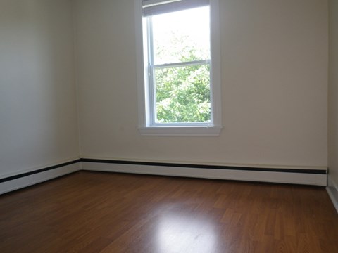 A room with a window and wooden floors.