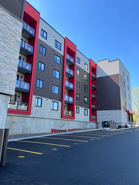 A multi-story building with a parking lot in front.