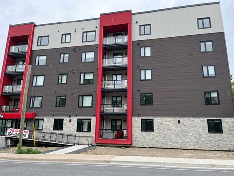 A multi-story apartment building with balconies and doors.