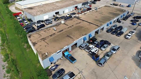 An aerial view of a parking lot with cars parked in rows.