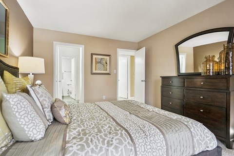 A bedroom with a large bed and a dresser.