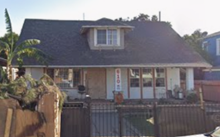 A house with a brown fence and a sign on it.