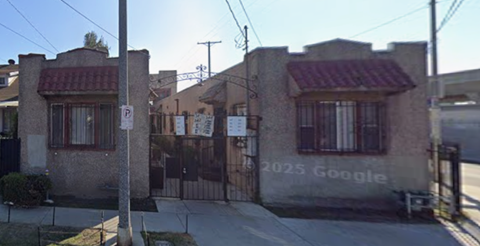 A street view of a residential area with houses and a parking sign.