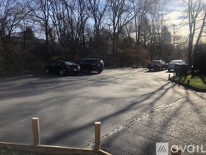 A parking lot with cars and trees in the background.