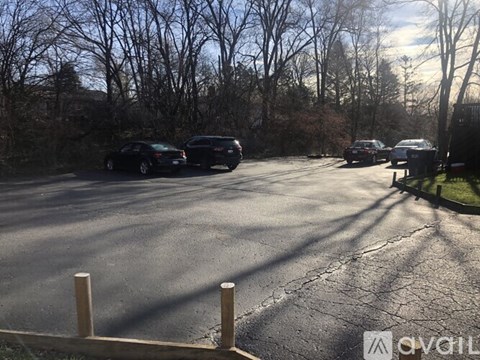 A parking lot with cars and trees in the background.