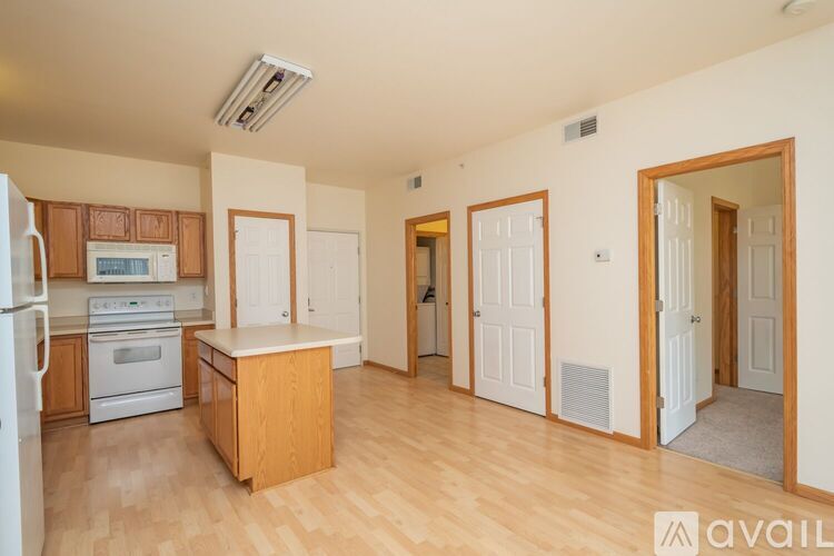 A kitchen with white appliances and wooden cabinets.