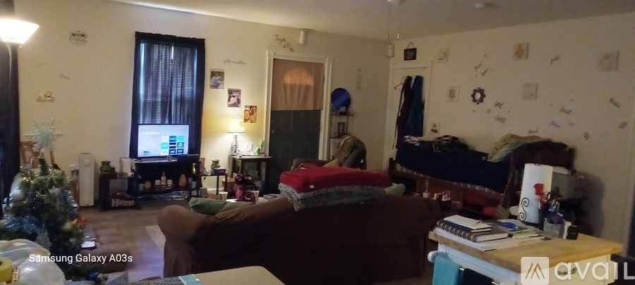 A living room with a couch, a television, and a Christmas tree.
