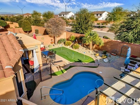 A backyard with a pool and a small lawn.