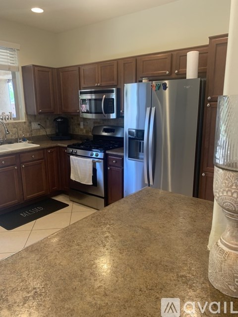 A kitchen with a granite counter top and a refrigerator.