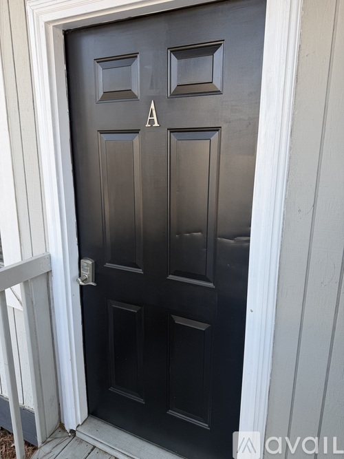 A black door with a white frame and a letter A above the door.