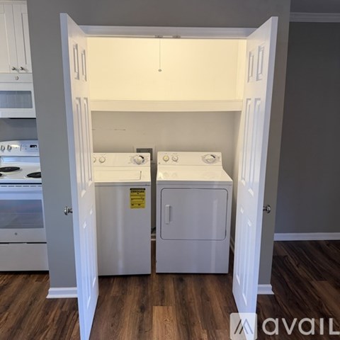 A small white kitchen with a dishwasher and a washing machine.