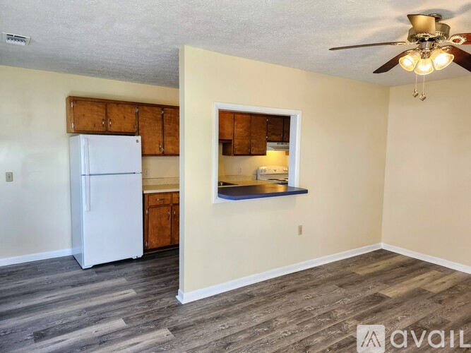 A kitchen with a white refrigerator and wooden cabinets.