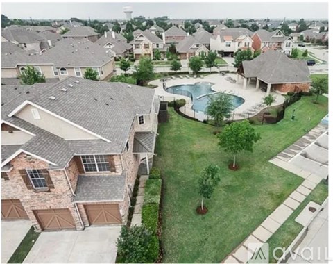 A bird's eye view of a neighborhood with houses and a pool.
