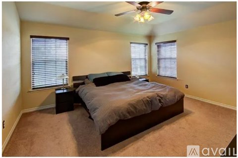 A bedroom with a bed, nightstands, and a ceiling fan.