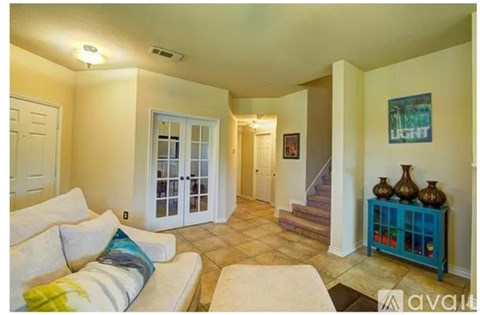 A living room with a white couch and a blue side table.