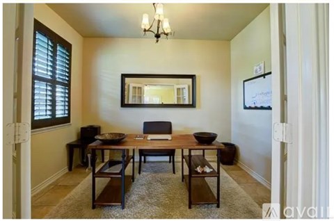 A dining room with a wooden table and chairs.
