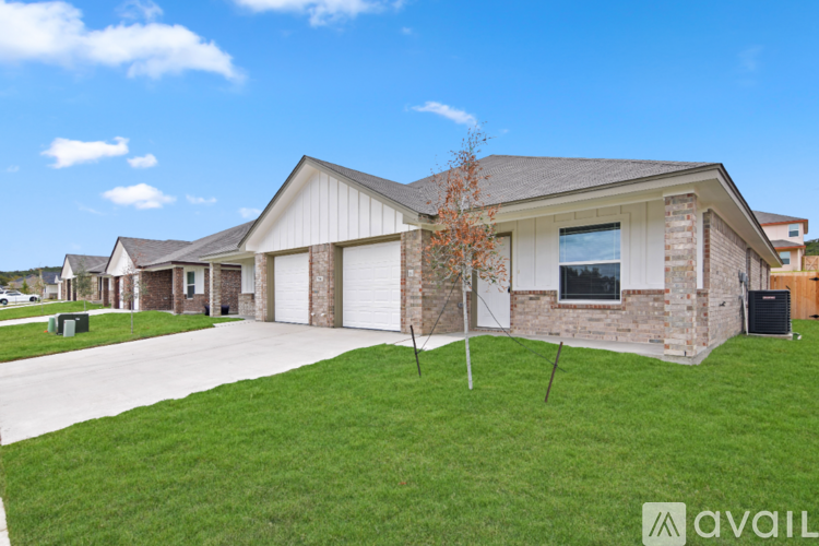 A house with a white garage door and a brown brick wall.
