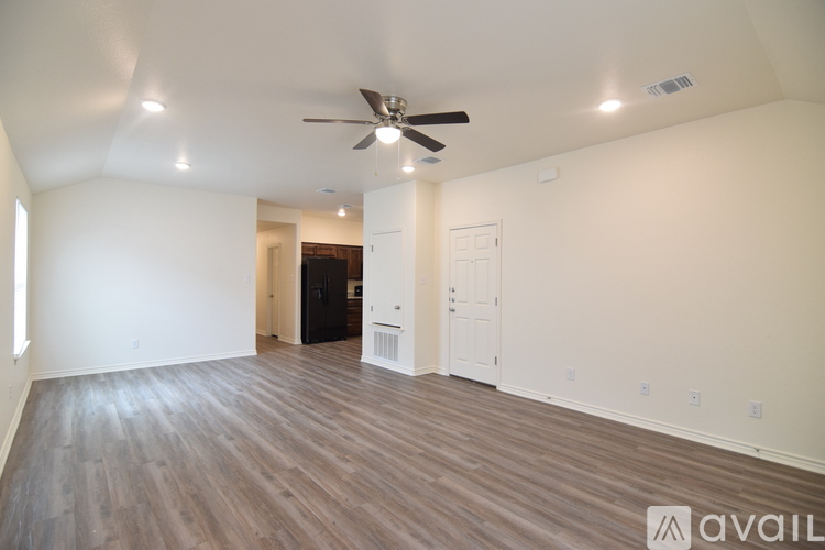 A spacious room with a ceiling fan and wooden flooring.