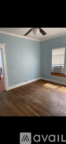 A room with a ceiling fan and wooden flooring.