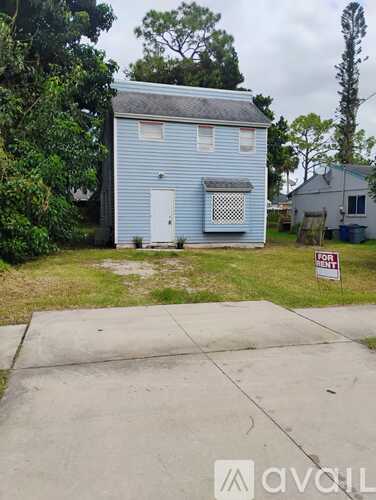 A blue house with a white door is for rent.