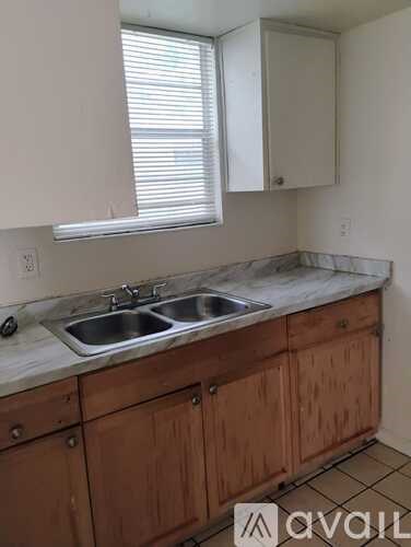 A kitchen with wooden cabinets and a marble countertop.