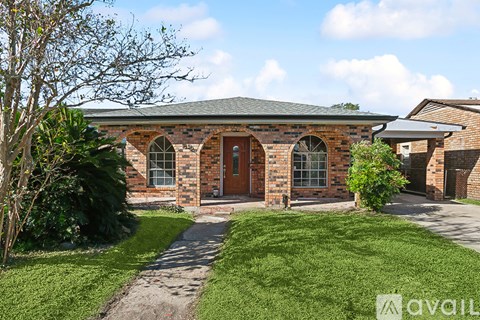 A house with a brick facade and a green lawn in front.
