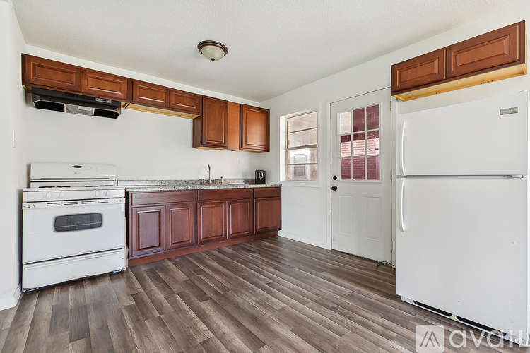 A kitchen with white appliances and wooden cabinets.