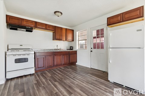 A kitchen with white appliances and wooden cabinets.