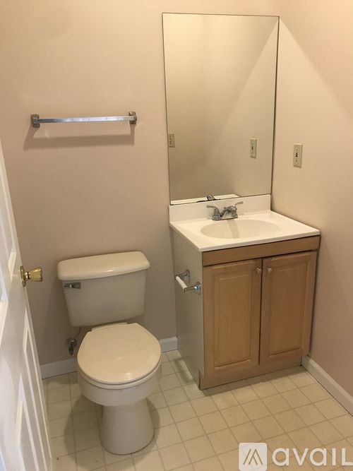 A bathroom with a toilet, sink, and medicine cabinet.