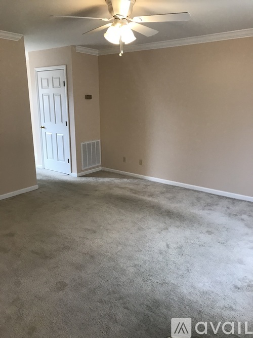 A room with a ceiling fan and a closed door.