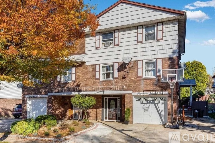 A two-story house with a garage and a basketball hoop.