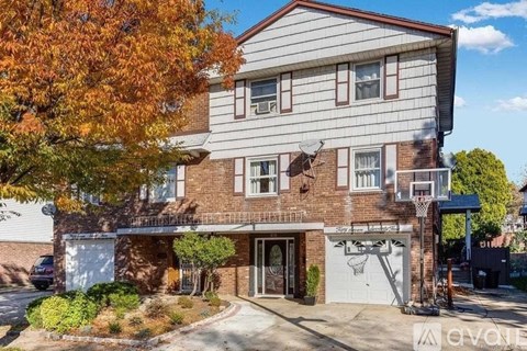 A two-story house with a garage and a basketball hoop.
