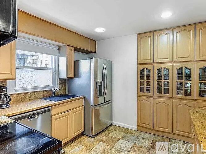 A kitchen with wooden cabinets and a black countertop.