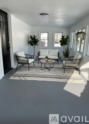 A living room with a rug and chairs.
